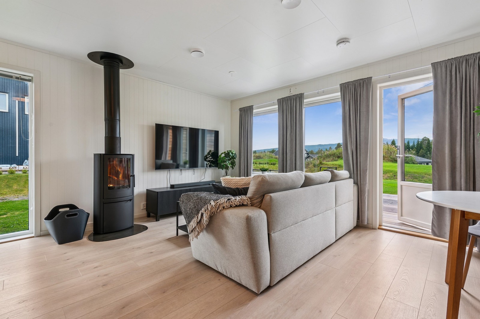 Stuen er et lunt samlingspunkt med vedovn og store vinduer med 3-lags isolerglass. Galleribilde