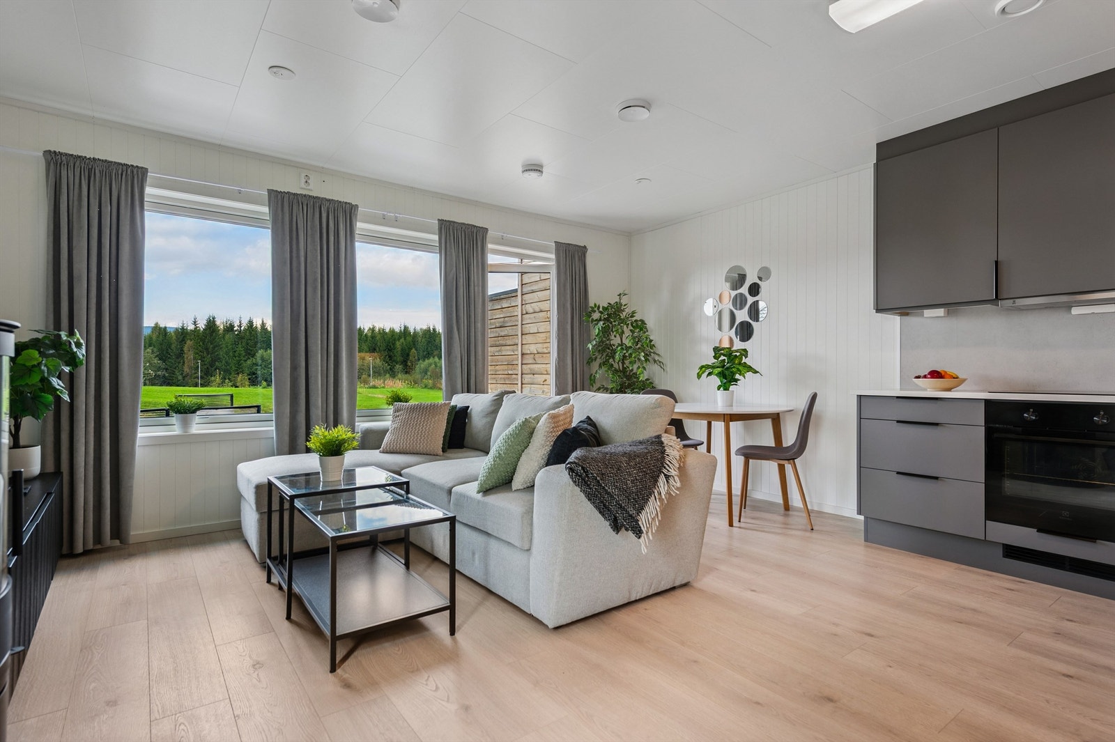 Gjennomgående laminatgulv og lyse panelplater på veggene gir en helhetlig og åpen følelse. Galleribilde