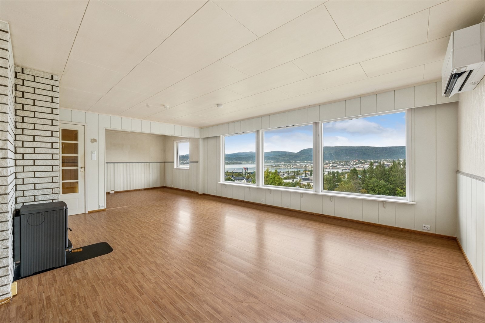 Stuen har store vindusflater som slipper inn rikelig med naturlig lys, noe som gir rommet en lys og luftig følelse. Galleribilde