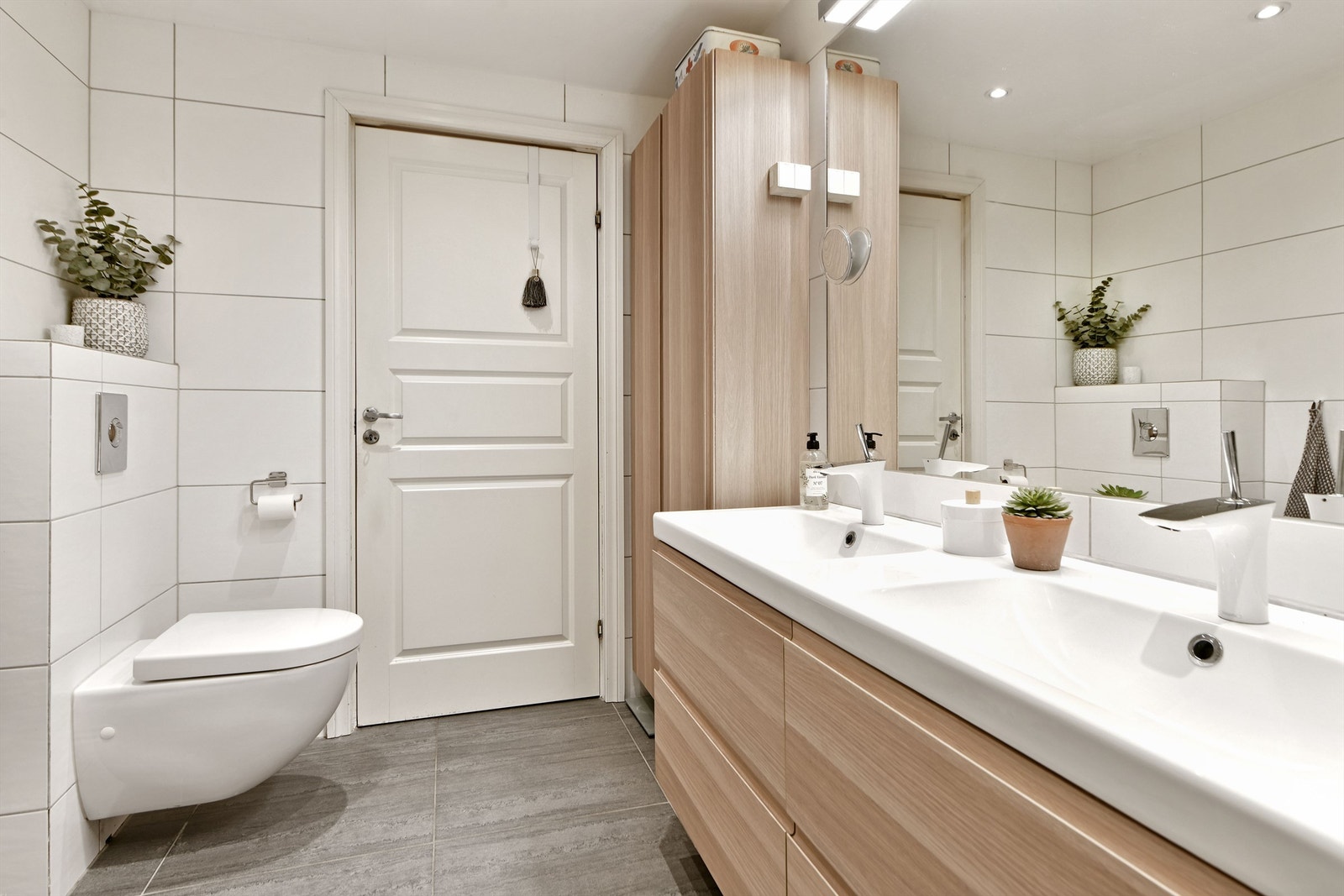 Bad - innfelt speil med belysning og stikkontakter over servant - baderomsinnredning med glatte fronter og heldekkende dobbelservant med ett-greps armatur Galleribilde