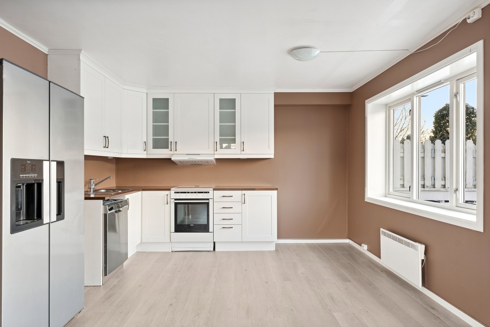 Tidløst kjøkken, med moderne dobbeltkjøleskap. Galleribilde