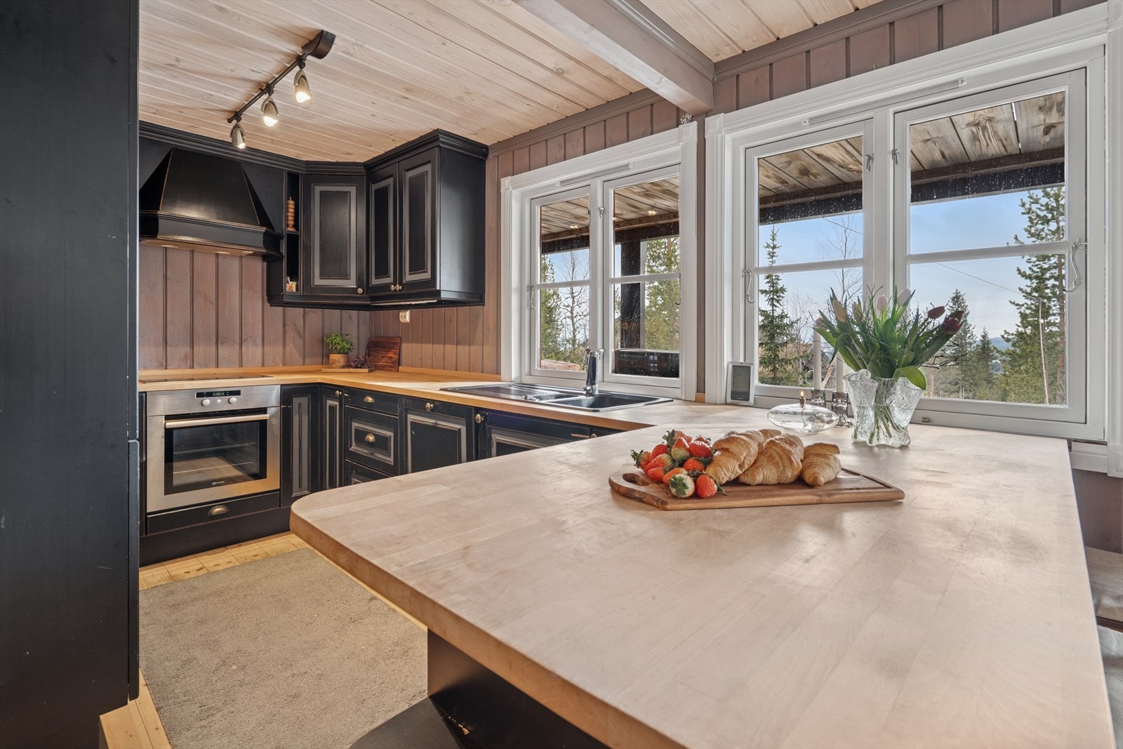 Kjøkkenen med benkeplate av heltre og kjøkkenventilator med avtrekk ut. Galleribilde