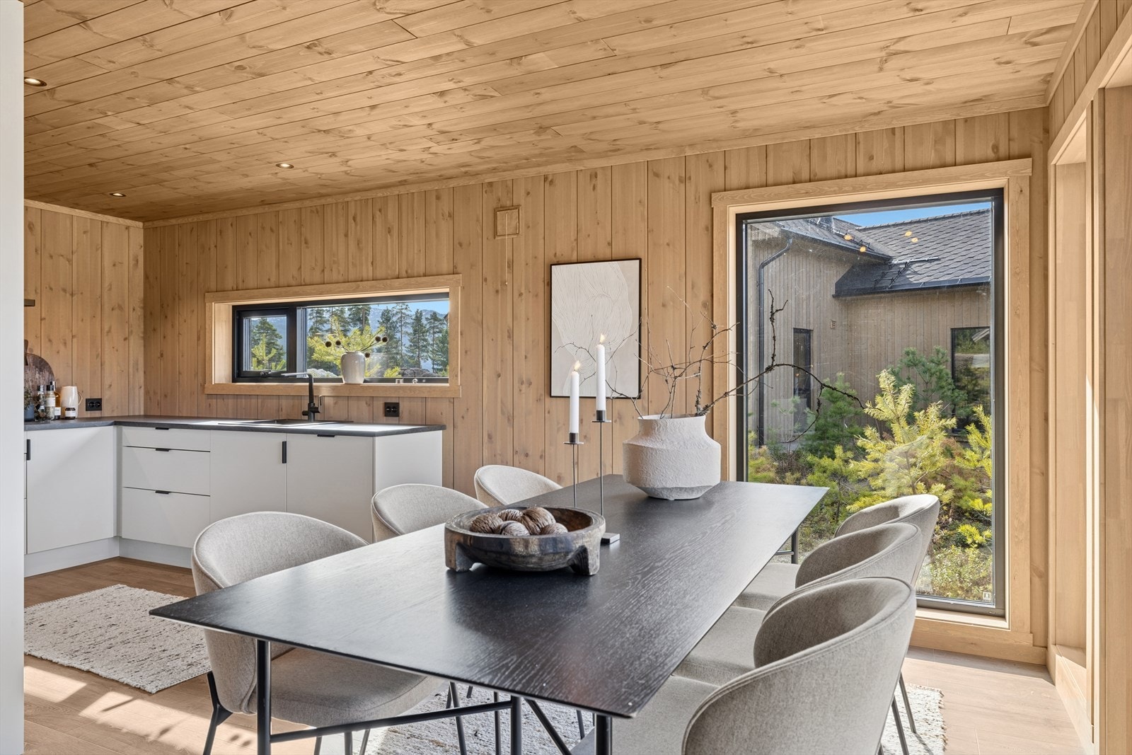 Tidløs hvit kjøkkeninnredning uten overskap. Lys og fin sone for spisebord. Galleribilde