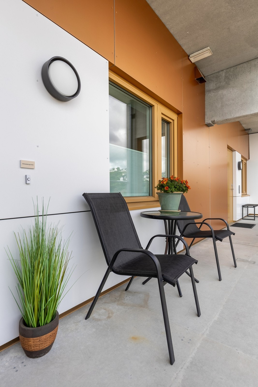 På svalgangen ved inngangspartiet er det plass til kafèbord og stoler. Her er det sol fra grytidlig morgen hvor man kan nyte morgenkaffen i sola Galleribilde