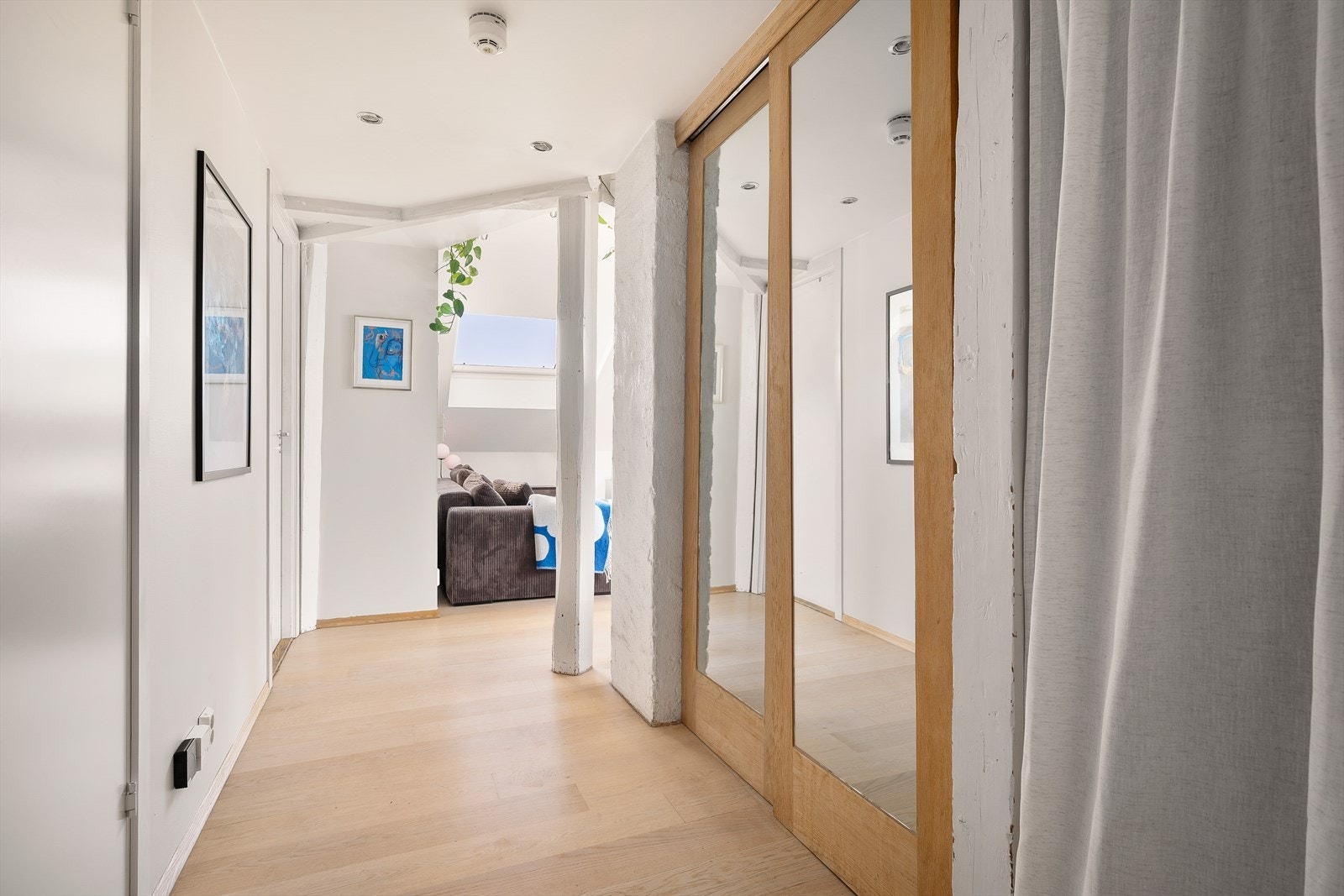 Entré innredet med skyvedørsgarderobe samt liten nisje for oppbevaring Galleribilde