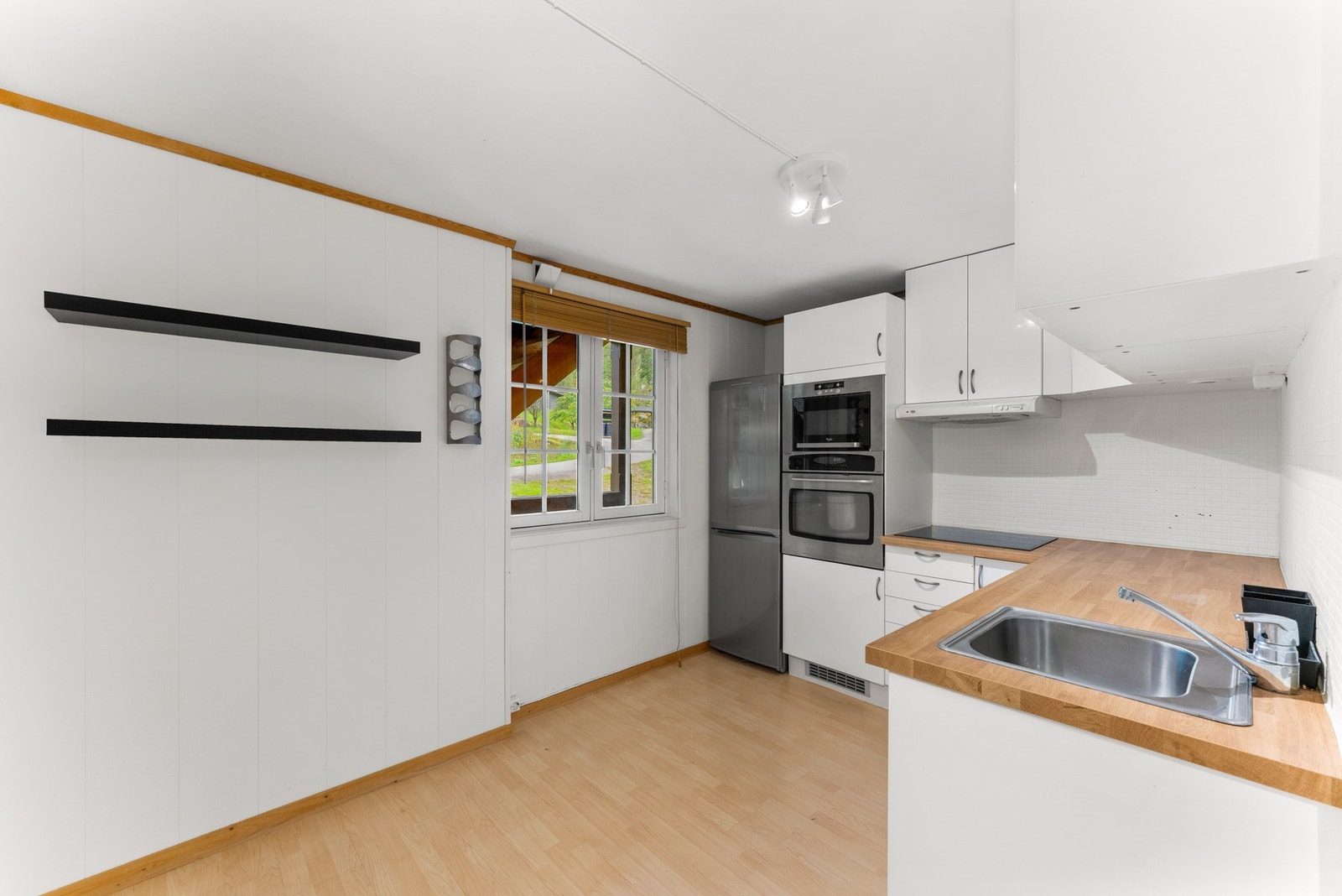 Kjøkkenet har en enkel og tidløs utforming med glatte fronter og laminat benkeplate. Galleribilde