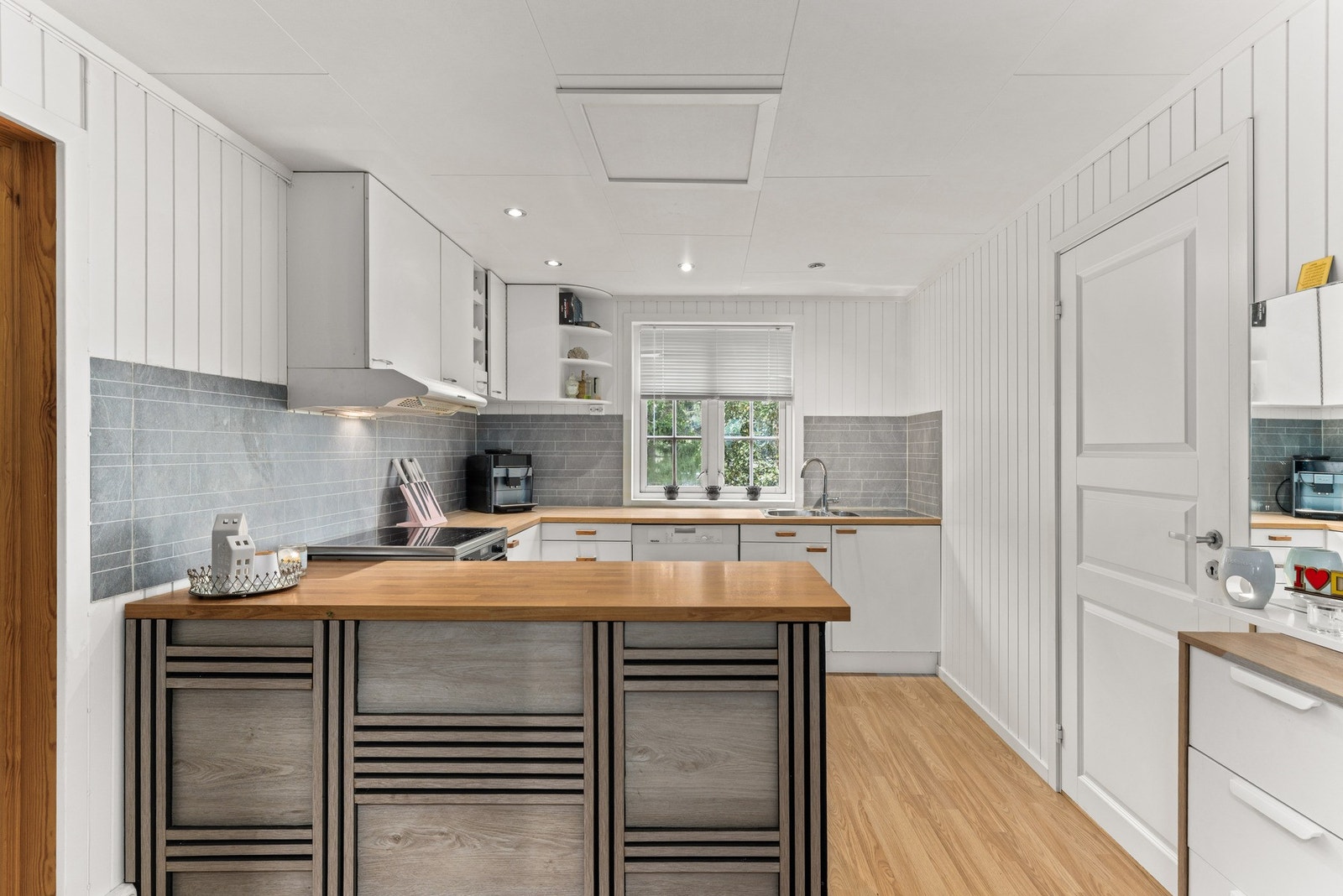 Kjøkkenet er praktisk utformet i U-løsning med glatte fronter og laminat benkeplate. Galleribilde