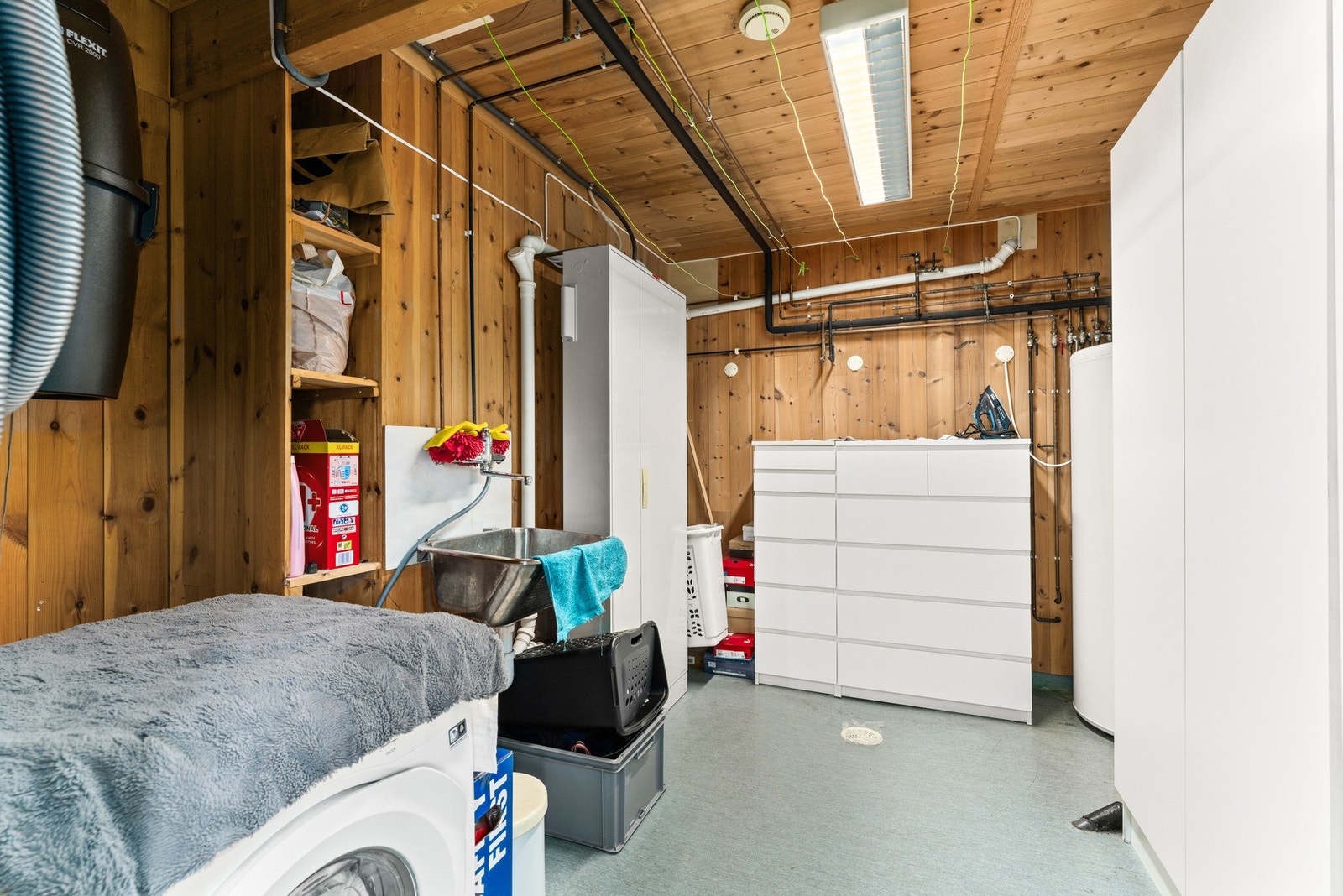 Vaskerommet har vegger i panel/tømmer og tak med panel, samt gulv med vinylbelegg og elektriske varmekabler. Her finner du opplegg for vaskemaskin, utslagsvask og naturlig ventilasjon. Galleribilde