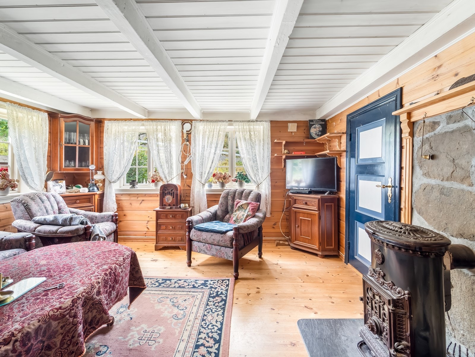 Stue med synlige bjelker og vedovn - gir huset sjel. Galleribilde