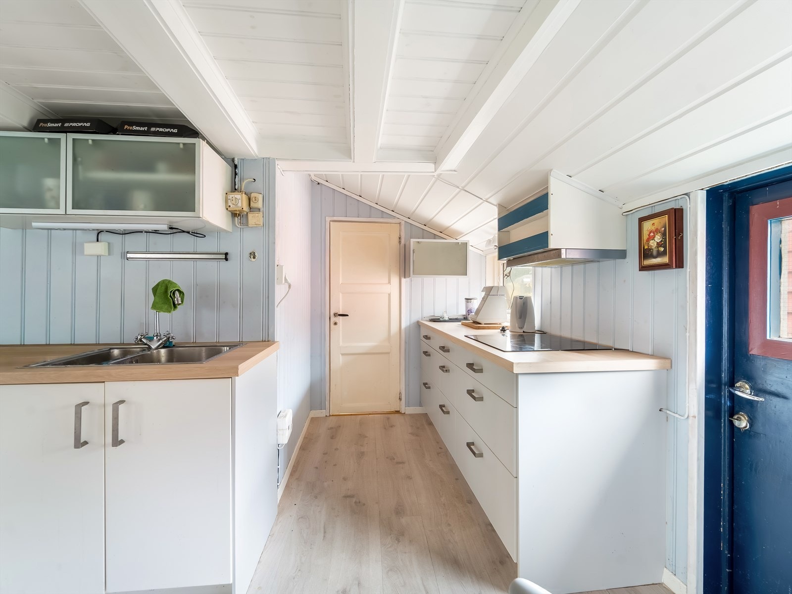 Lys kjøkkeninnredning med enkle løsninger og rikelig skapplass. Galleribilde