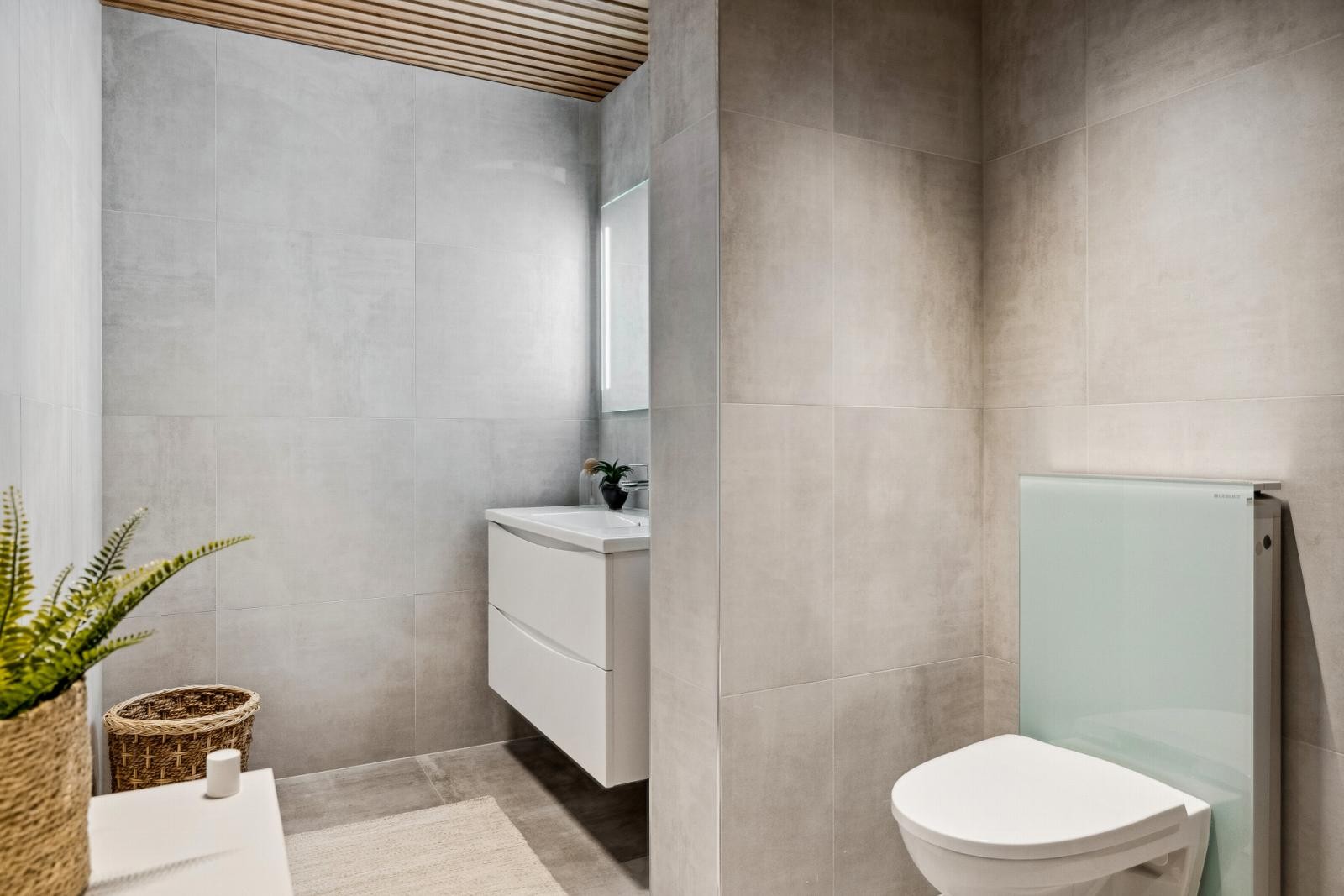 Delikat baderom med 60x60 flis på gulv og vegg. Baderommet har eikespiler i himling. Varmekabler med termostat i gulv på baderom og gang. Galleribilde