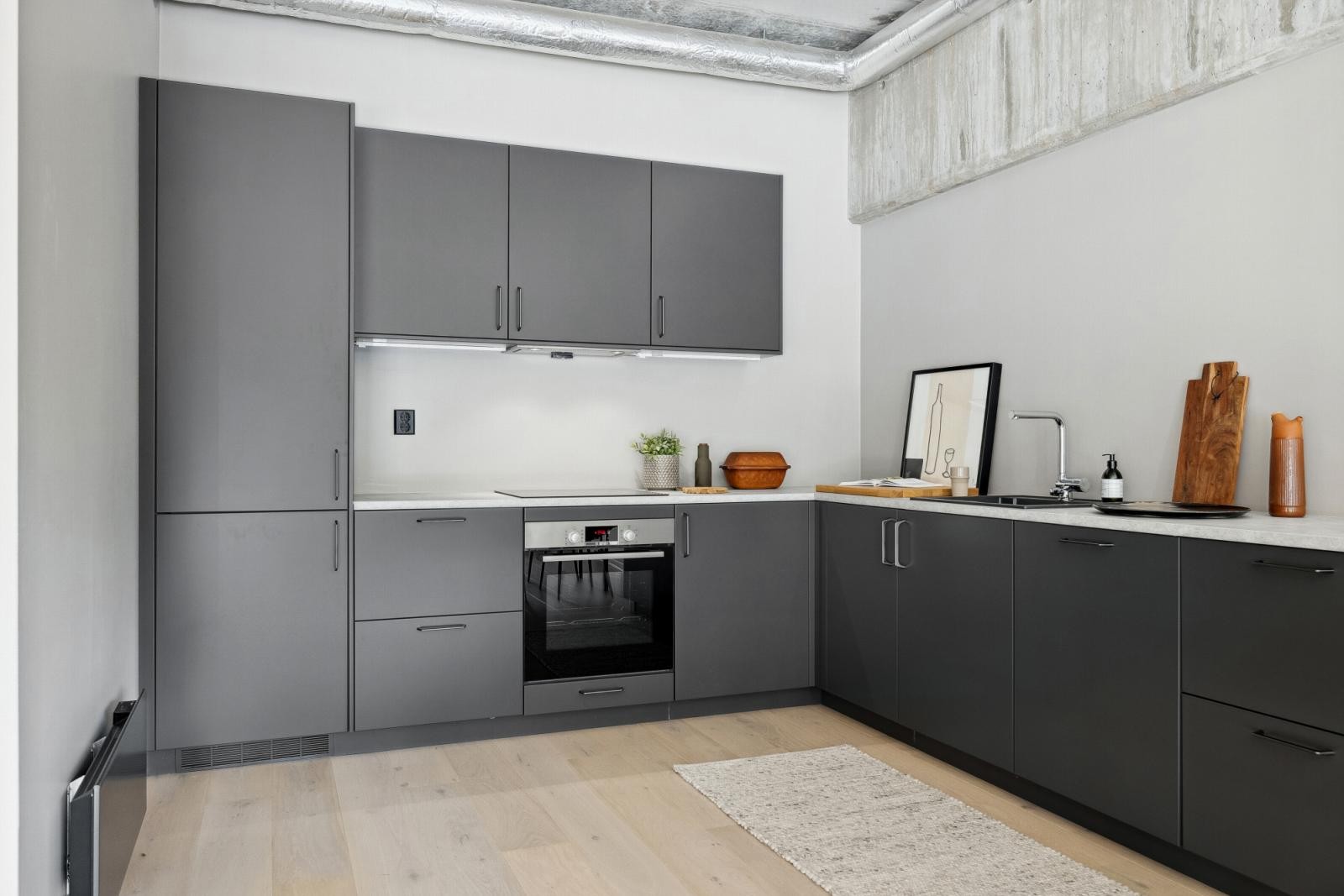 Kjøkkeninnredning og integrerte hvitevarer fra Drømmekjøkken. Laminat benkeplate m/rett kant. Induksjon platetopp, stekeovn, oppvaskmaskin og kjøl/frys, samt ventilator med kullfilter. 1 meter LED list under overskap. Galleribilde