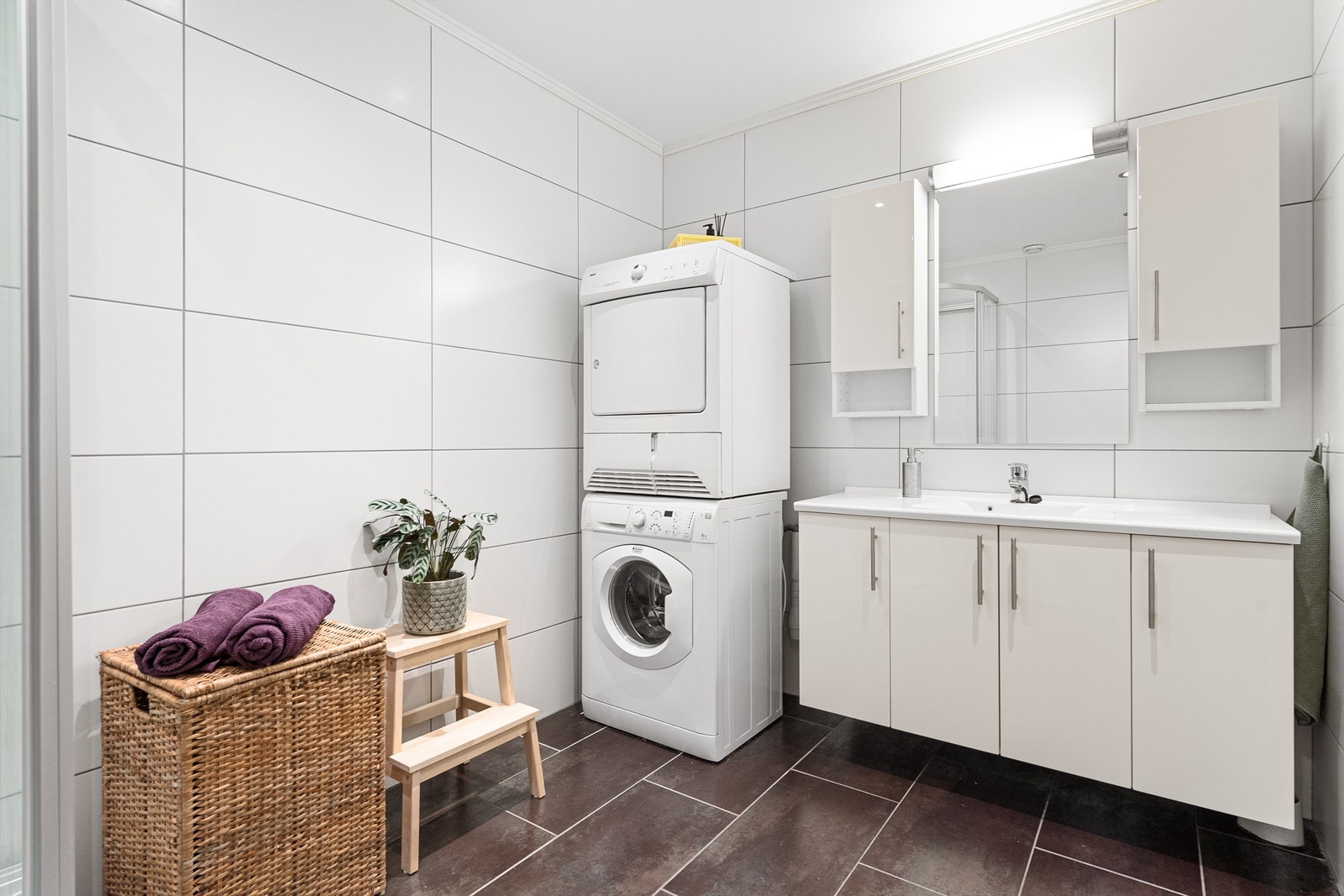 Badet har hvit innredning med heldekkende servantplate. Opplegg for vaskemaskin og tørketrommel. Galleribilde