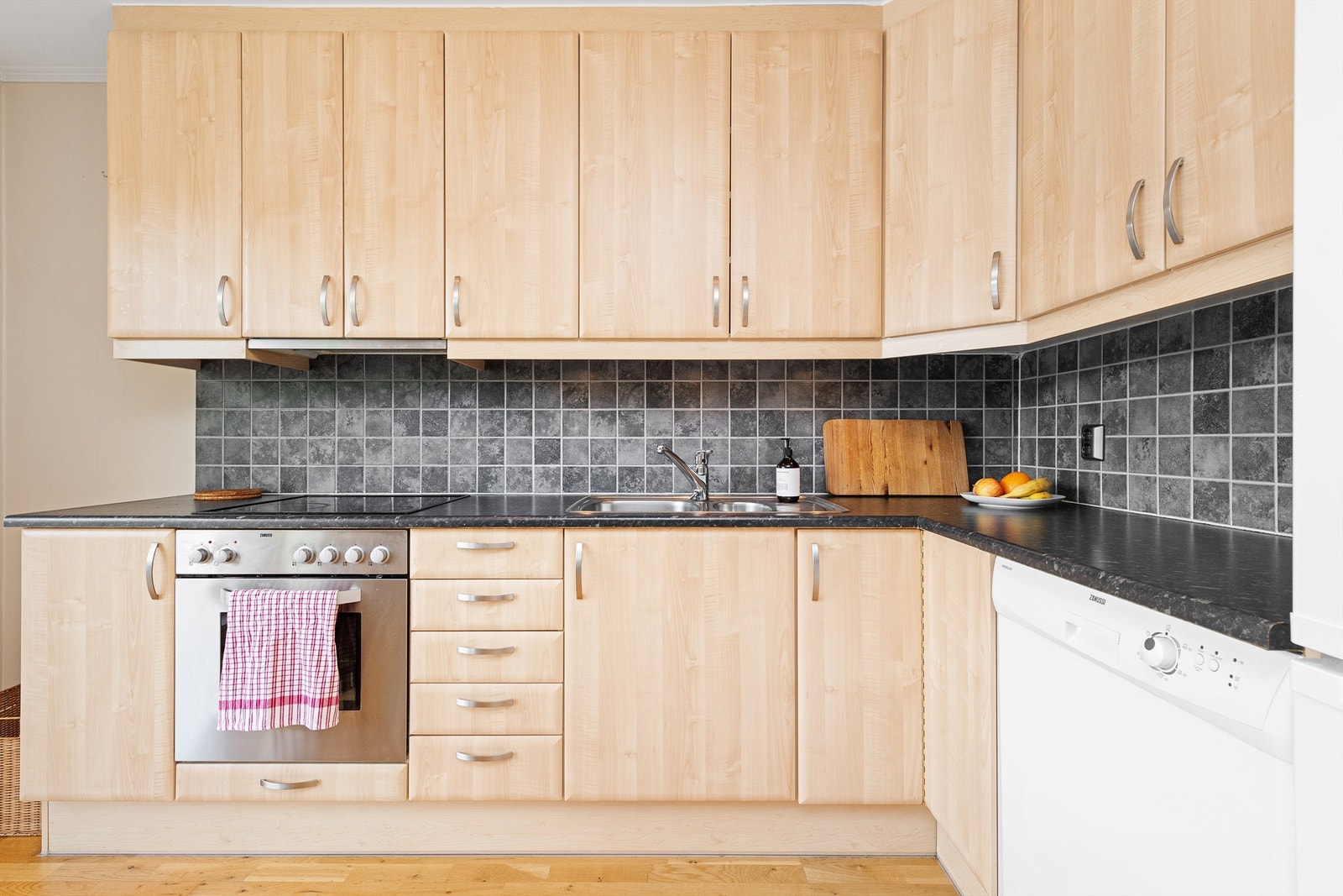 Lys kjøkkeninnredning med god skap- og benkeplass Galleribilde