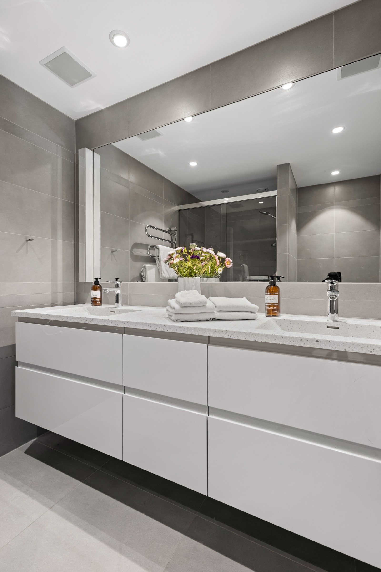Badet i 1. etasje er fra 2014 og har store, fine fliser på vegger og gulv. Rommet er innredet med dusj m/skyvedør, servantskap med heldekkende dobbel servant i Corian og stort speil over servanten samt elektrisk håndkletørker og vegghengt toalett. Galleribilde