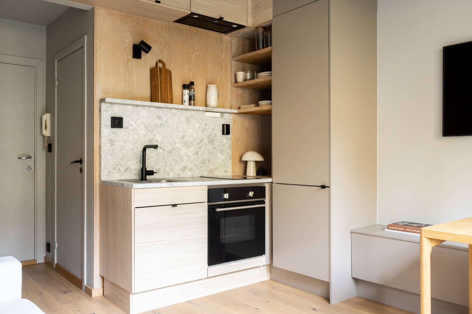 Moderne uttrykk med steinmønstret benkeplate, sort armatur og praktisk innredning. Galleribilde