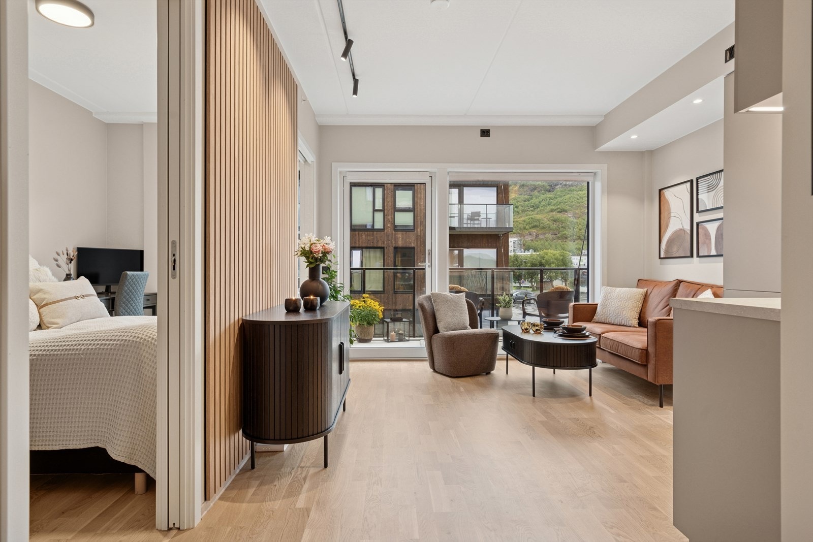 Stuen er utført med et pent parkettgulv, slette lysmalte overflater og en moderne kontrastvegg m/spiler Galleribilde