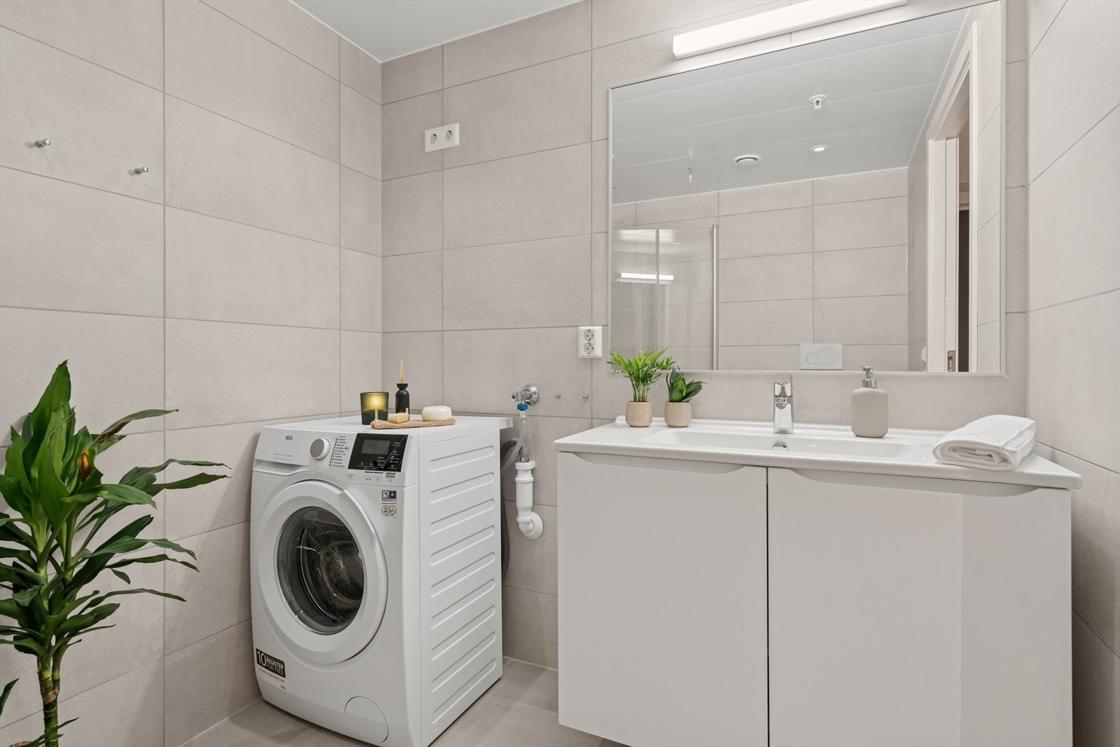 Innredningen består av servant med skap under og vegghengt speil med lys over Galleribilde