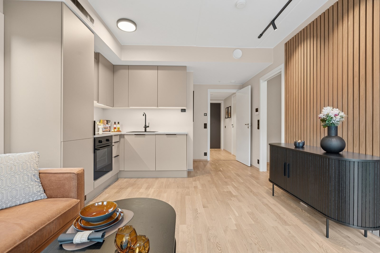 Kjøkkenet ligger i moderne åpen løsning og har en stilren innredning med slette malte fronter og laminert benkeplate med nedfelt komposittvask Galleribilde