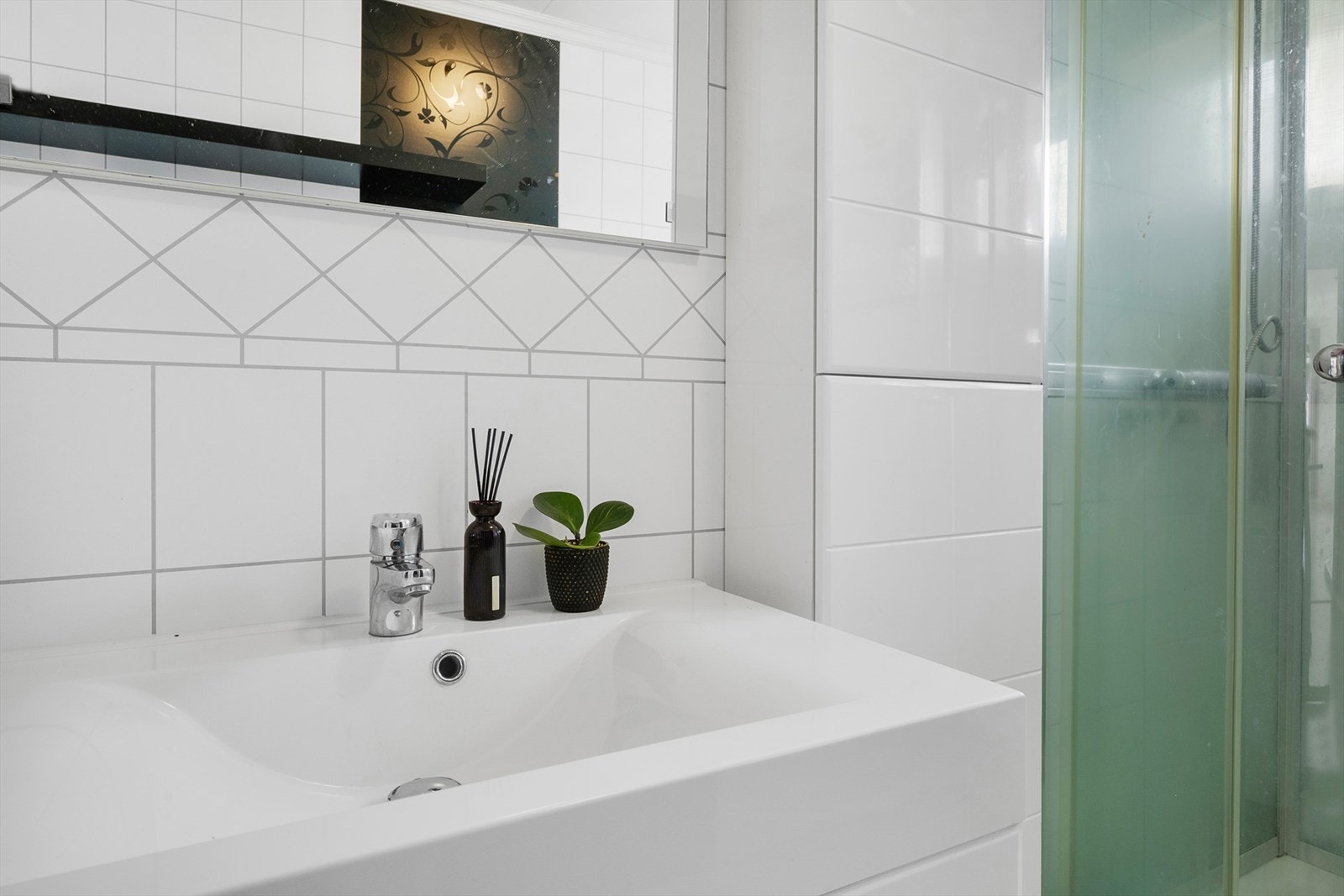 Badet har flislagte overflater og heldekkende servantplate. Galleribilde