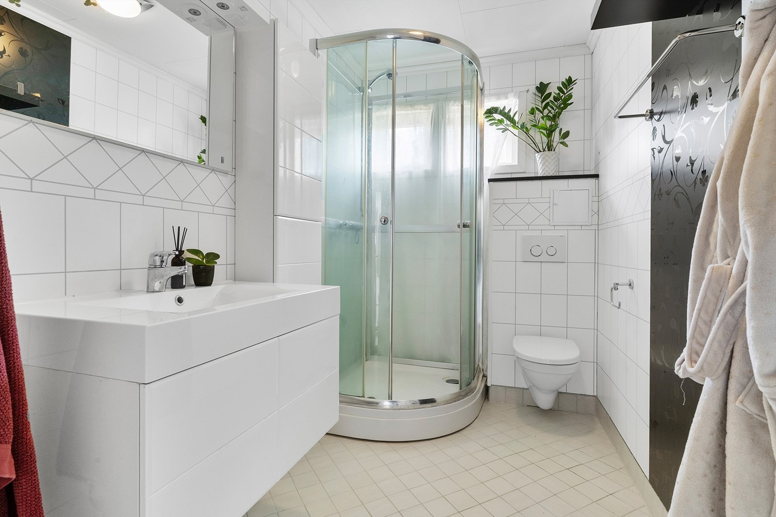 Badet i hovedetasjen er innredet med veggfestet WC, dusjkabinett og baderomsinnredning med servant. Galleribilde