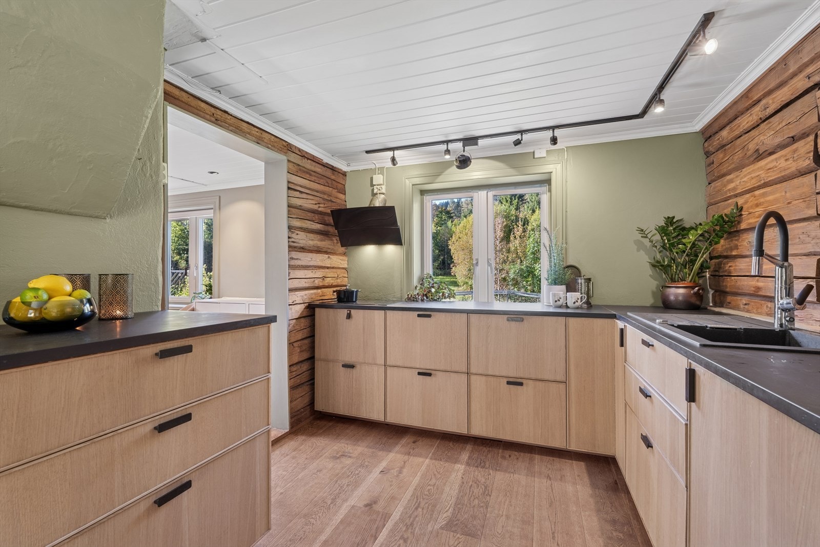 Veggen er malt i en grønn lun farge og passer godt sammen med tømmerveggene. Galleribilde