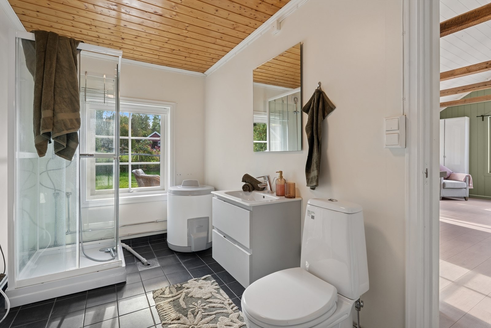 Baderom som er innredet med toalett, servant med skuffer og dusjkabinett. Galleribilde