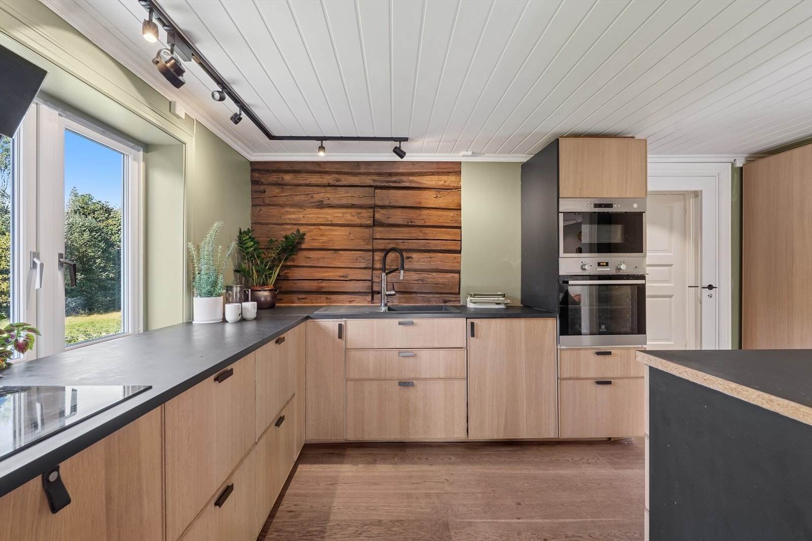 Kjøkkenet har integrerte hvitevarer og store vindusflater som gir rikelig med dagslys. Galleribilde