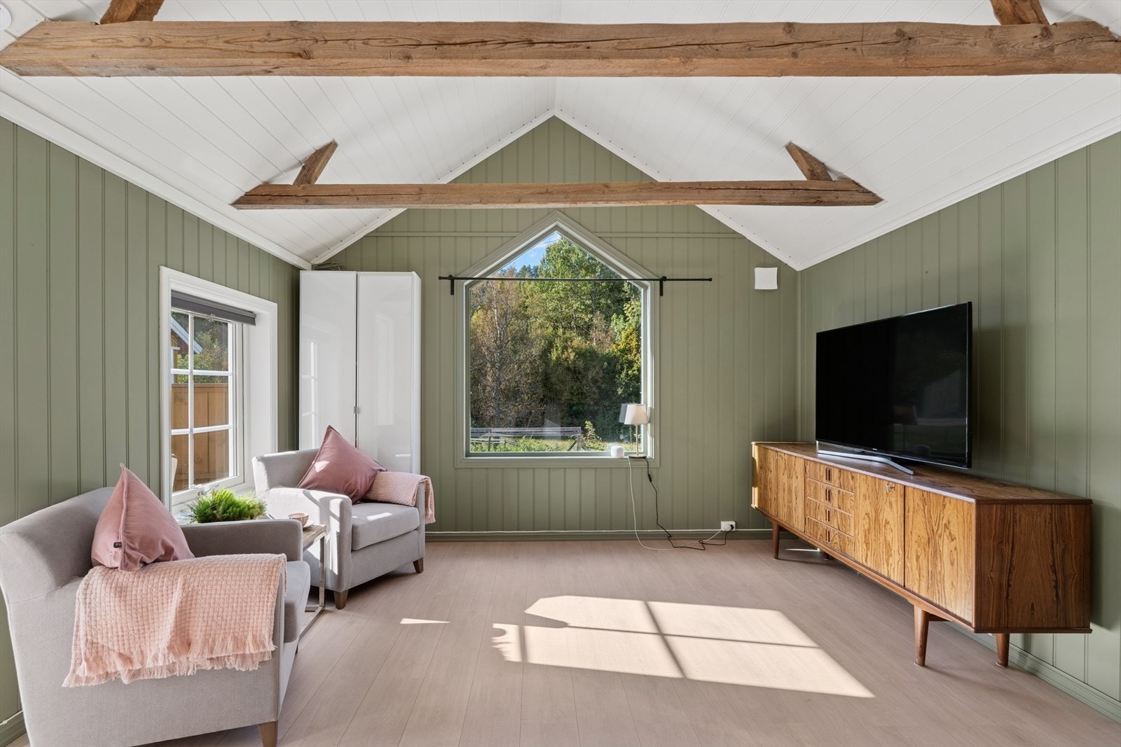 Stuen har en god takhøyde med synlige bjelker. Galleribilde