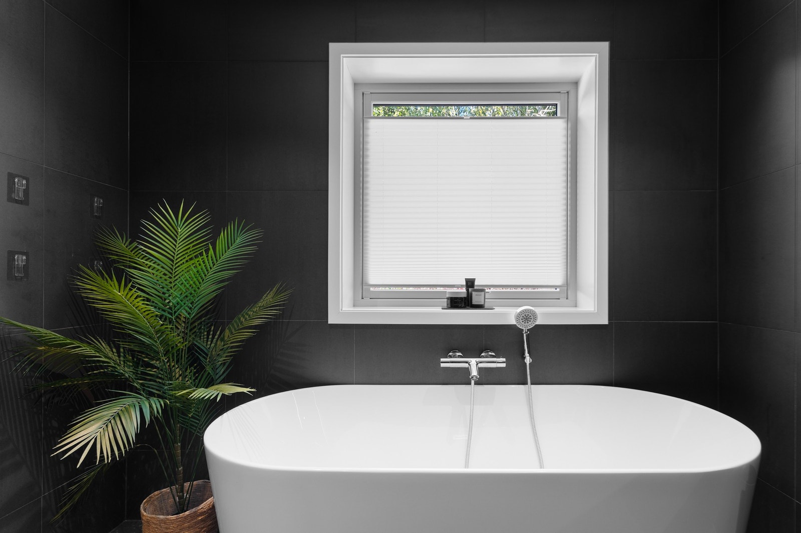 Badet i hovedetasjen er utstyrt med montert dusjkabinett, vegghengt toalett, servant på innredning og badekar Galleribilde