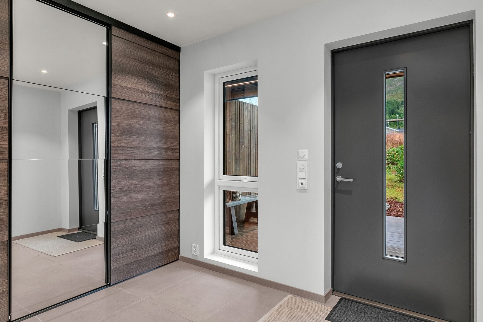 Lys og pen entré med flislagt gulv med gulvvarme Galleribilde