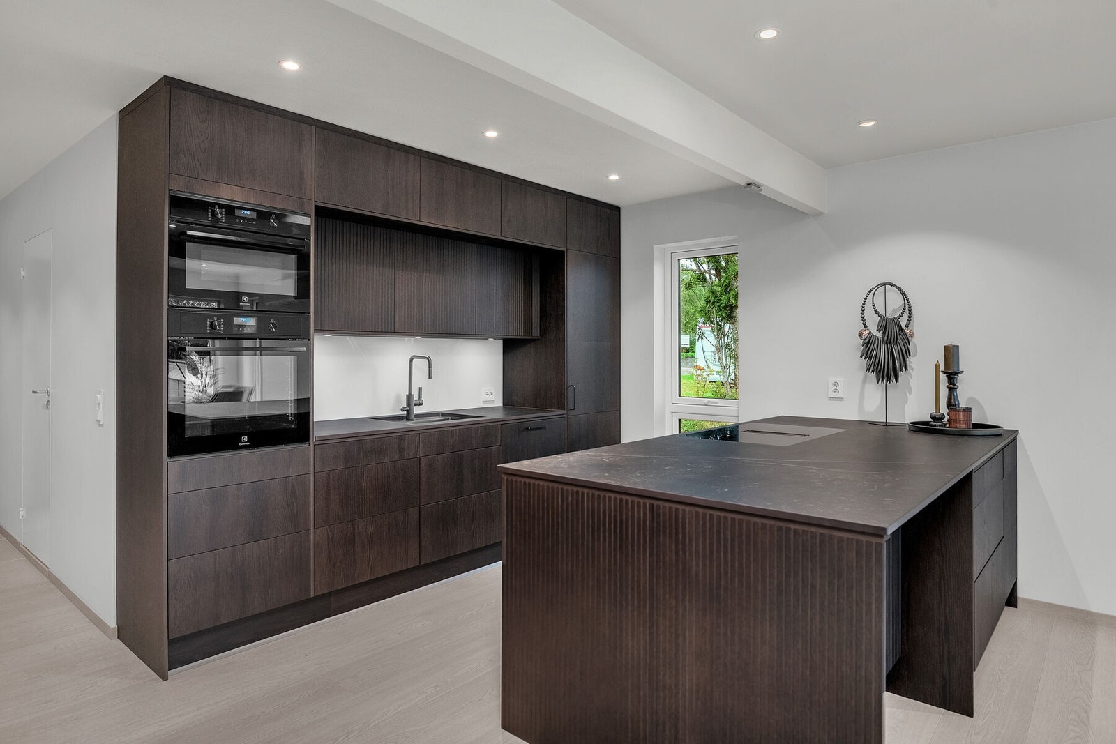 Delikat og praktisk kjøkken med god skap- og benkeplass, integrerte hvitevarer og kjøkkenøy Galleribilde