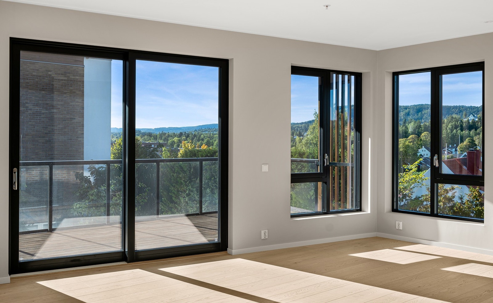 Store vindusflater og skyvedør ut til stor balkong Galleribilde