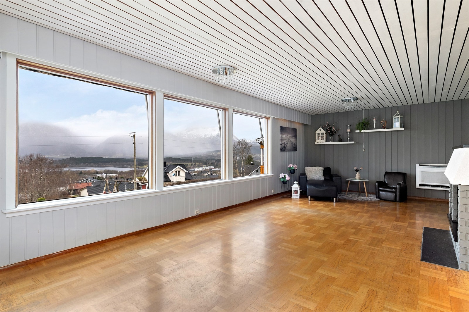 Stor stue med vakker utsikt mot fjell og vann. Store vinduer gir rikelig med naturlig lys og romfølelse. Galleribilde