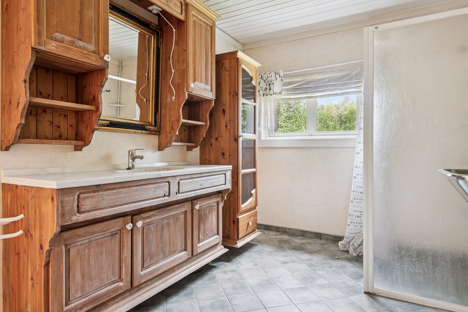 Badet i første etasje har flislagt gulv med varmekabler og en solid innredning med servant. Galleribilde