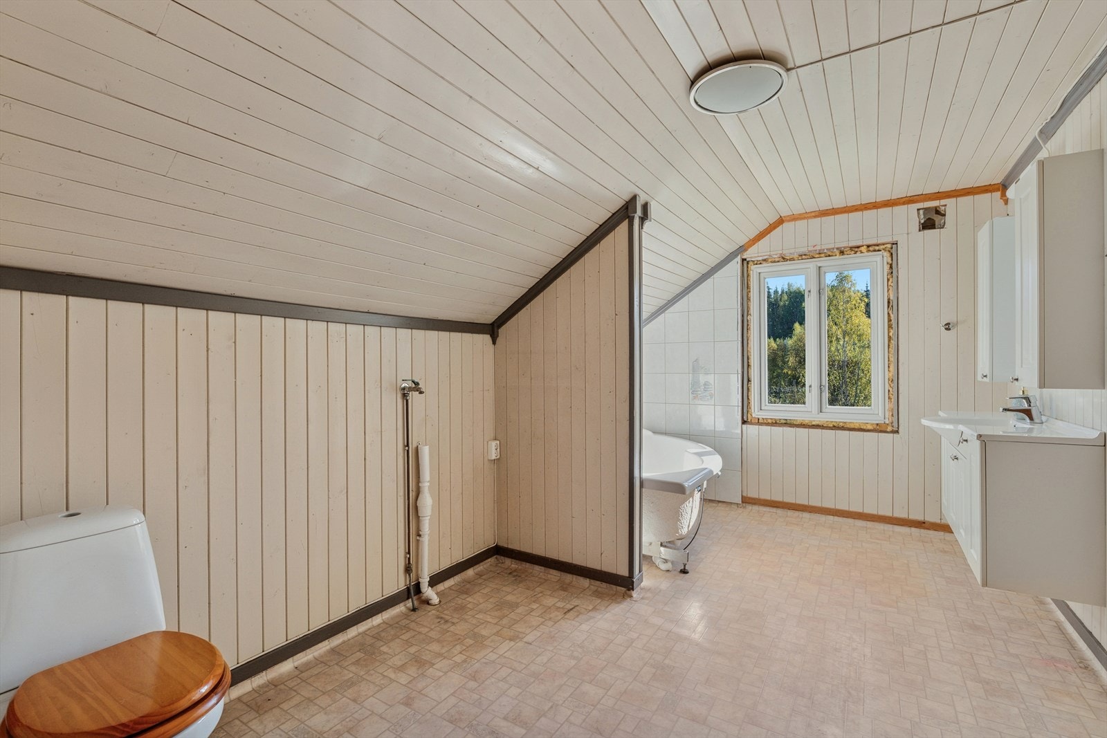 Boligen har et bad med belegg på gulv og panel på vegg. Galleribilde