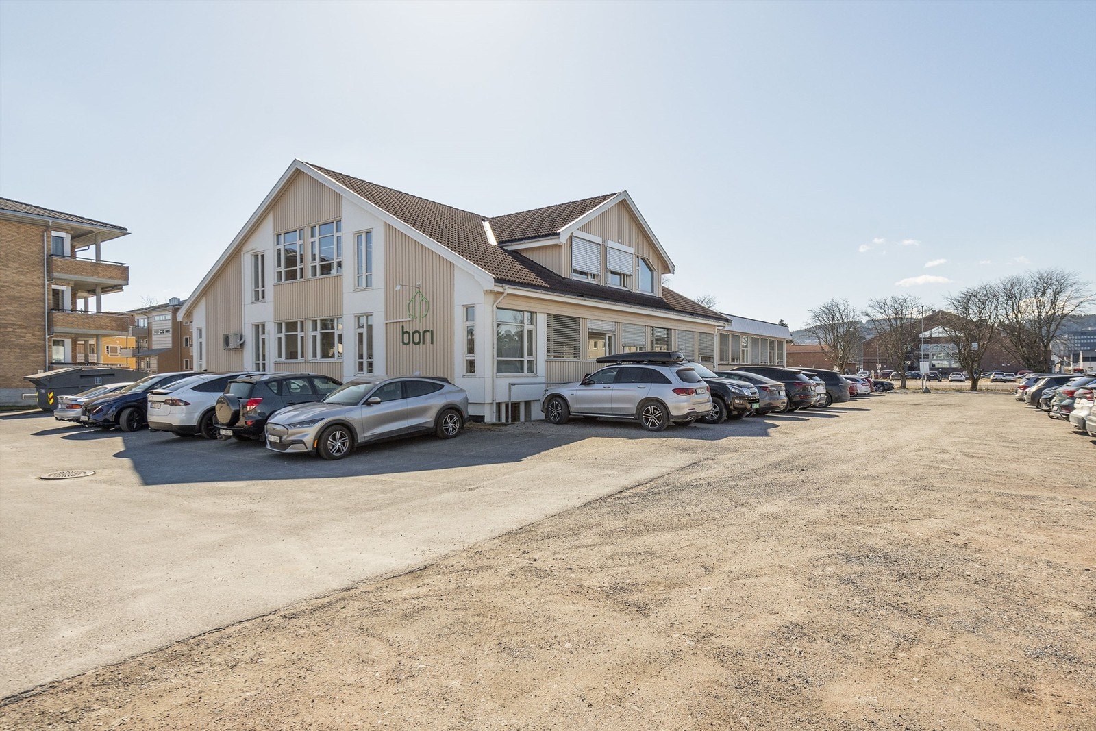 Flat tomt primært opparbeidet med grus, asfalt og plen. Galleribilde