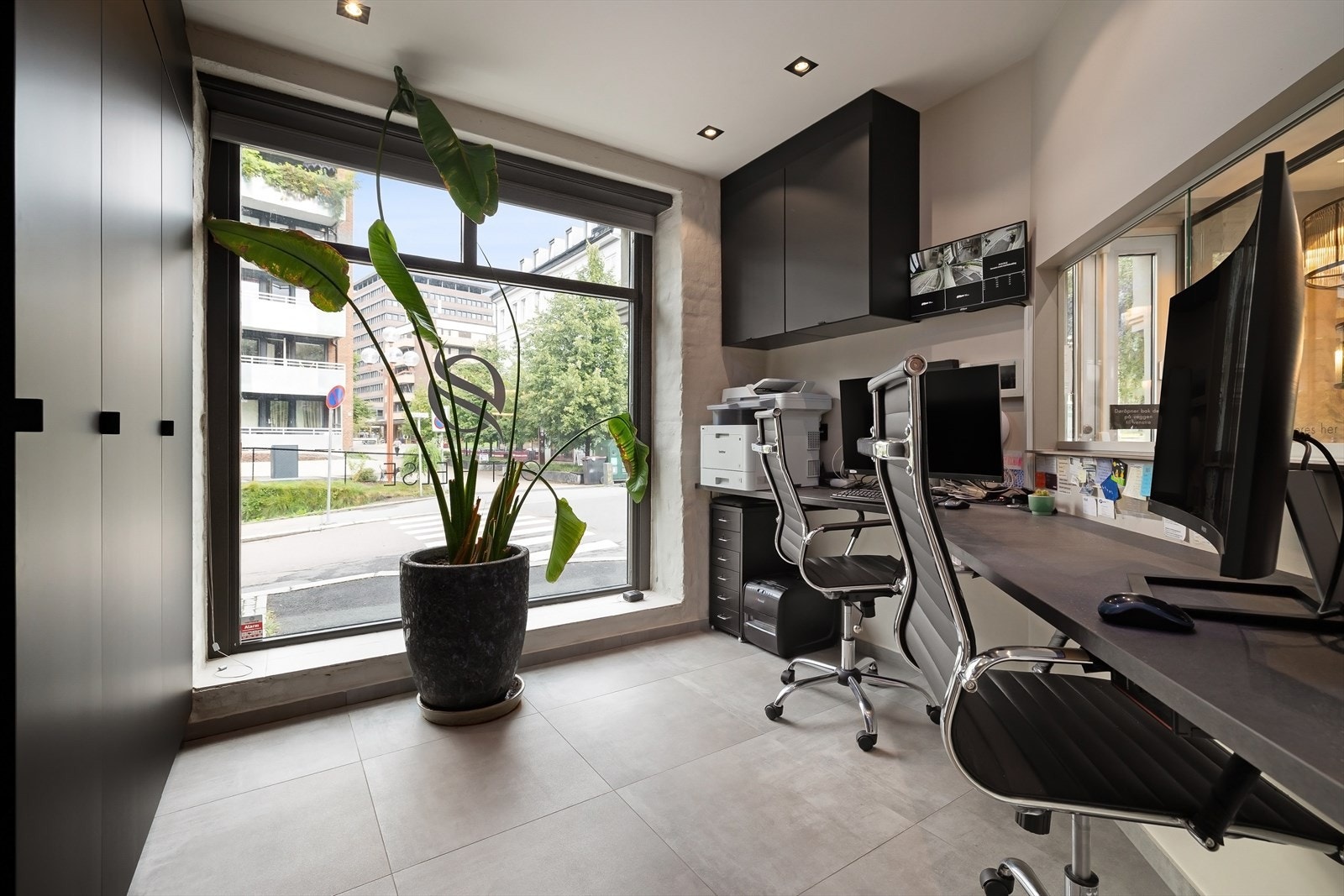 Praktisk resepsjon med to arbeidsplasser. Gode oppbevaringsmuligheter og med utsikt til pasientene på venterommet. Moderne overvåkningsutstyr med oversikt over kameraer innvendig og utvendig. Fra resepsjonen kan man åpne de to dørene til både overetasjen Galleribilde