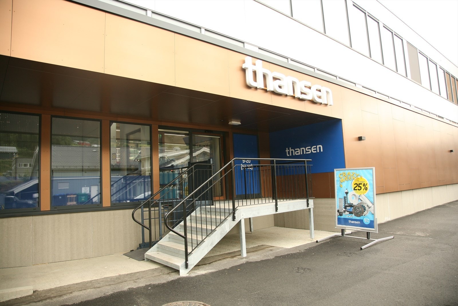 Inngangsparti til thansen som har butikk ved siden av ledige handelsareal.