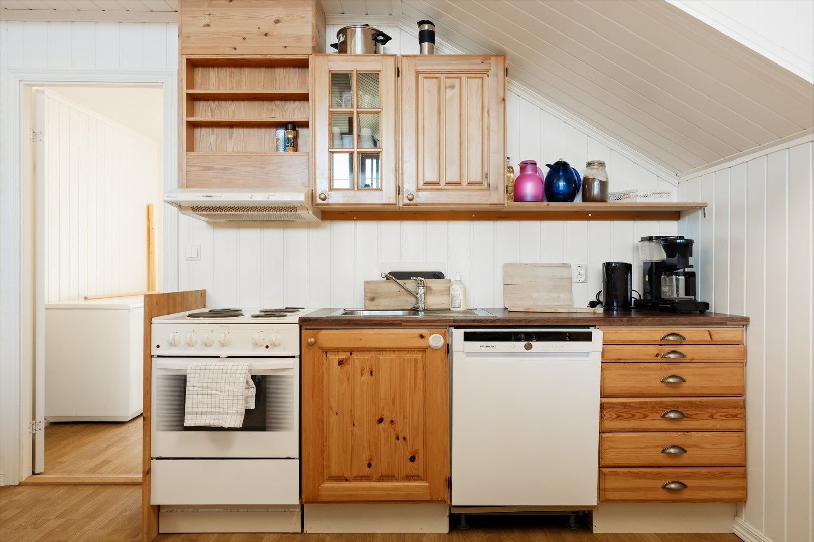 W | Enkel innredning med koketopp og ovn, oppvaskmaskin og oppvaskkum. Galleribilde