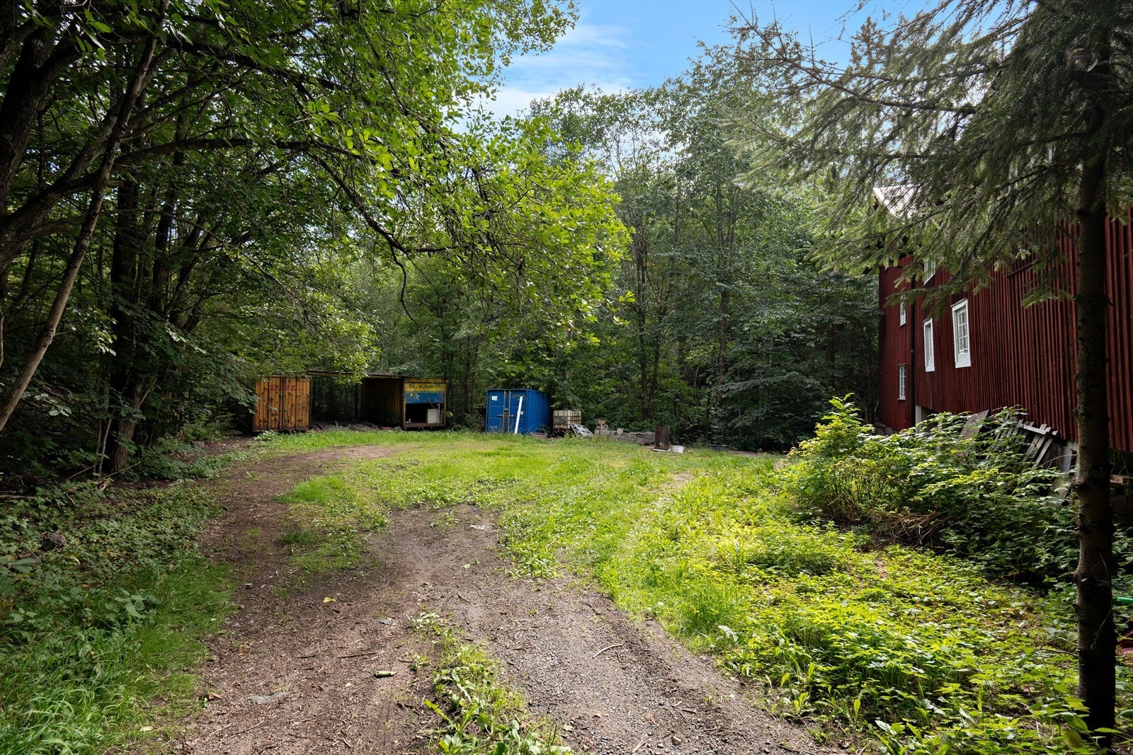 På nedsiden av tomten ligger står det to containere som medfølger handelen - Enkel takplate lagt mellom Galleribilde