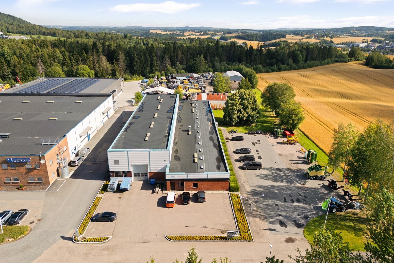 Eiendommen er flat, med asfalterte kjøre- og parkeringsareal Galleribilde