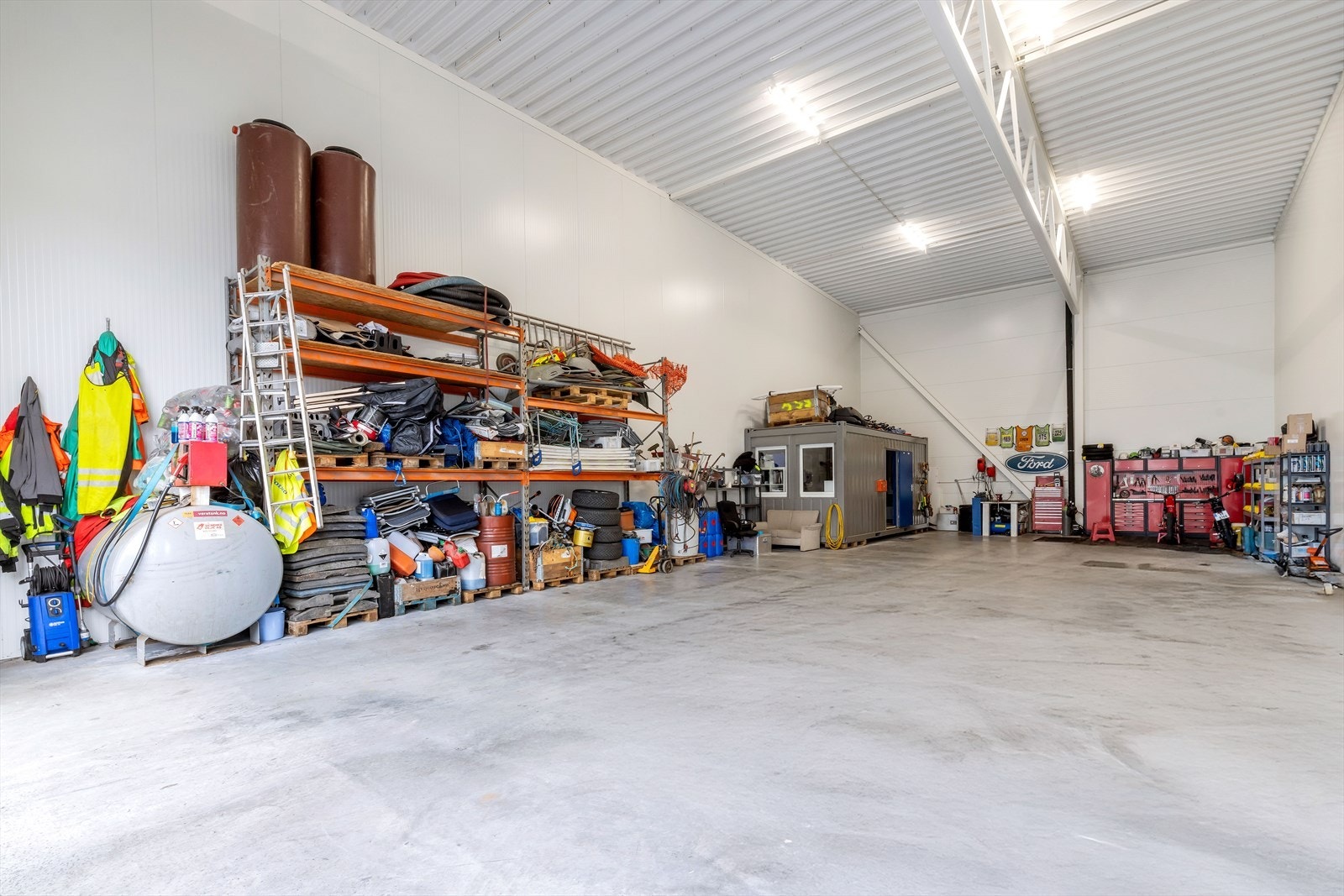 Praktisk innredet med hyllereoler, brakke og verkstedområde Galleribilde