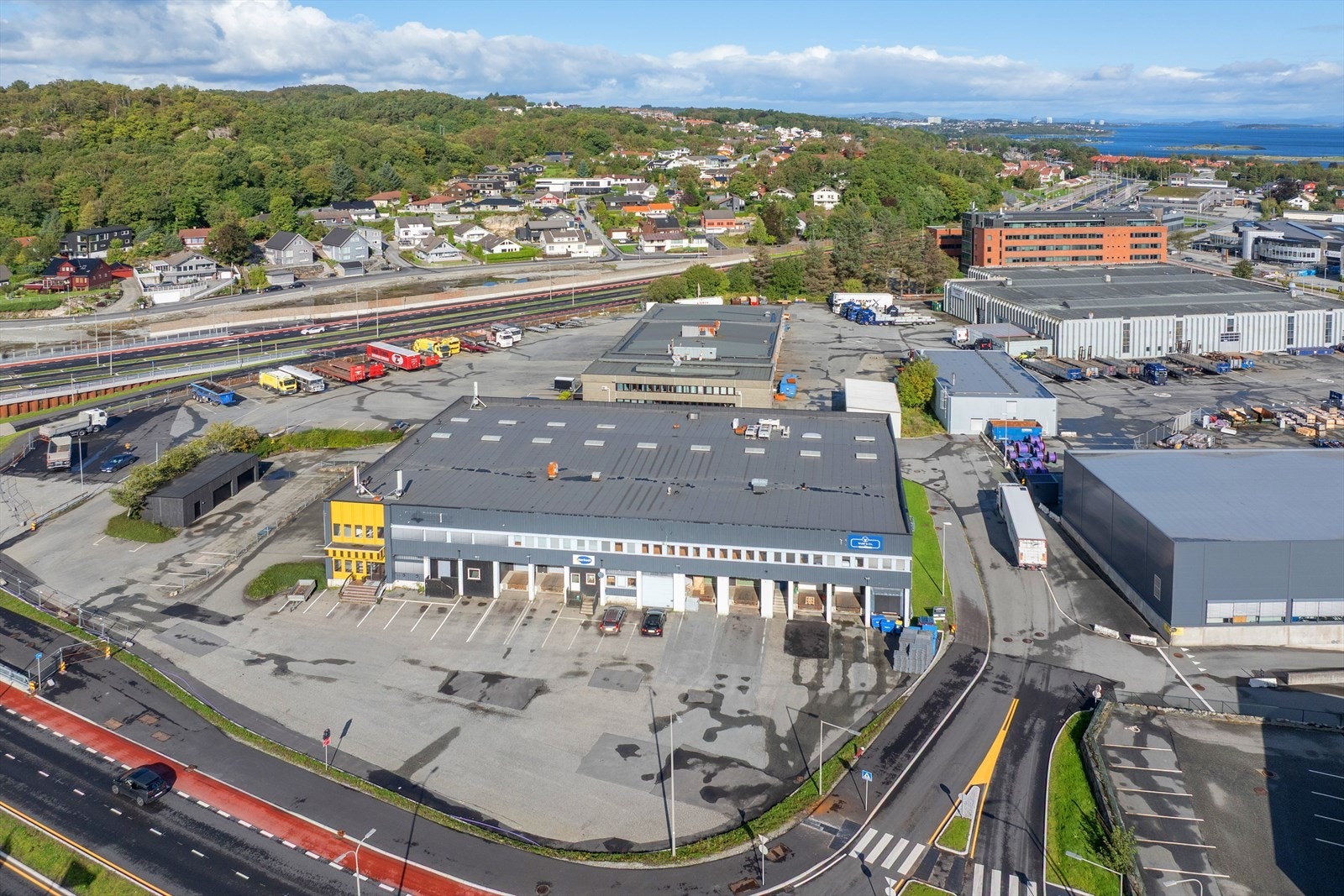 Moderne næringseiendom med strategisk beliggenhet nær vei og jernbane, omgitt av naturskjønt landskap og maritim utsikt. Galleribilde