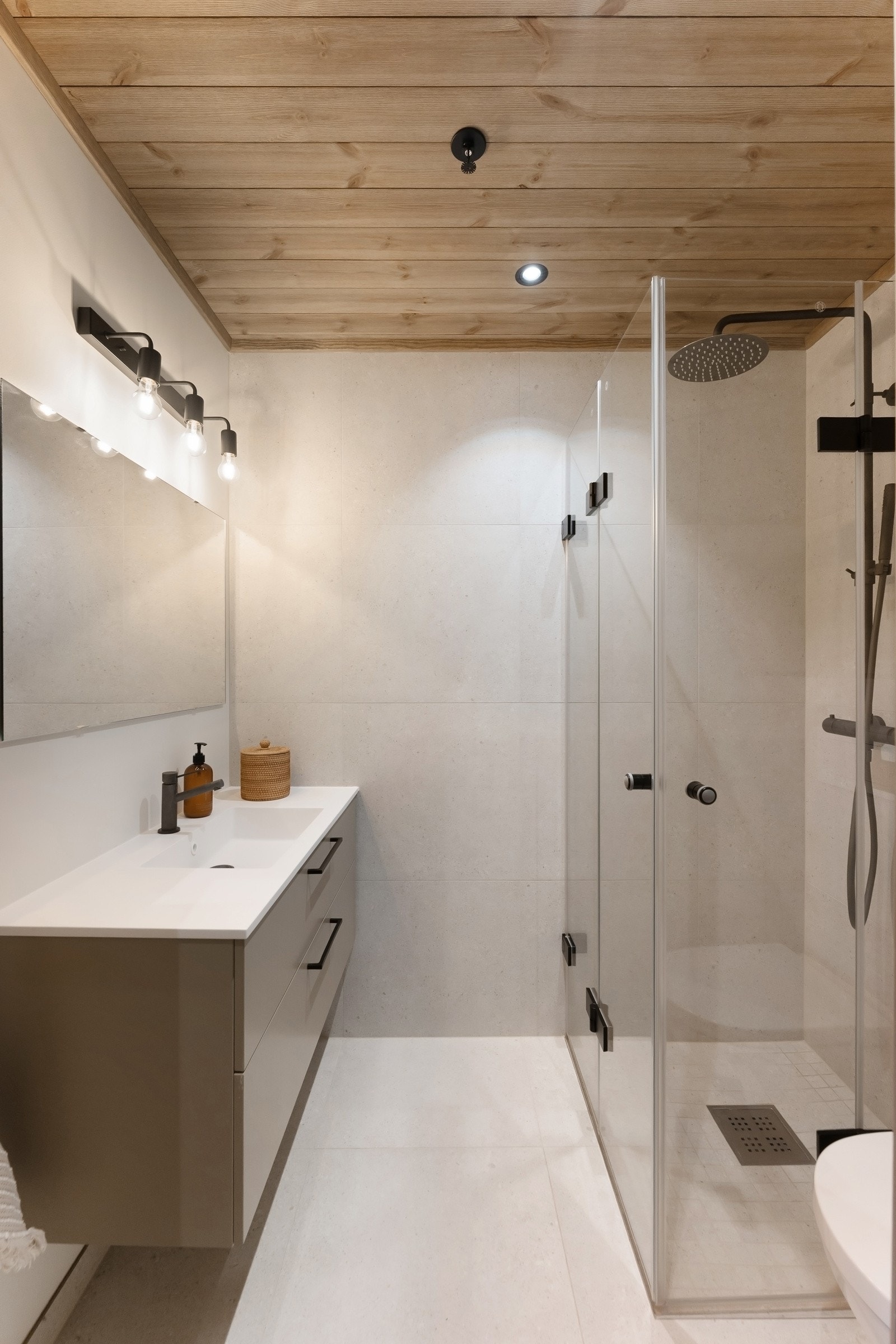 Bad i 3. etasje - Leiligheten har et bad i hver etasje. Begge badene er holdt i en delikat, gjennomført og moderne stil med downlights i himlingen, lyse vegger og matchende fliser på gulv med vannbåren gulvvarme. Galleribilde