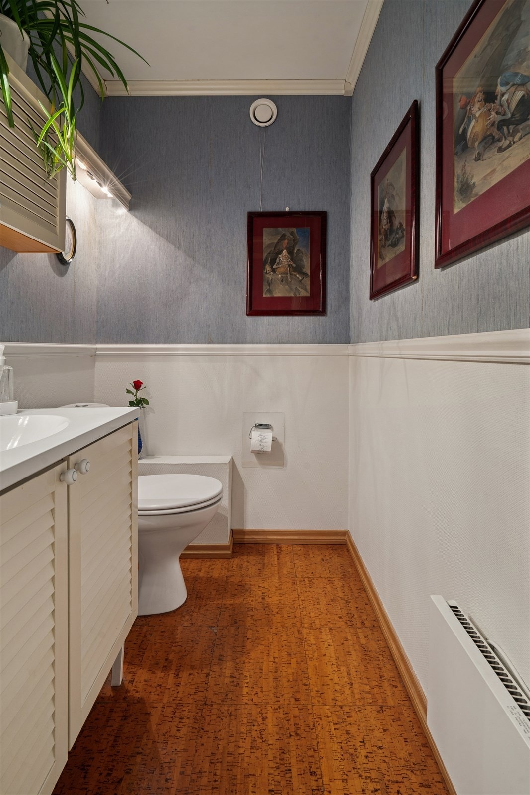 Toalettrommet er innredet med en hel nedfelt servant i et servantskap, overskap, speil med lys over og et klosett. Galleribilde