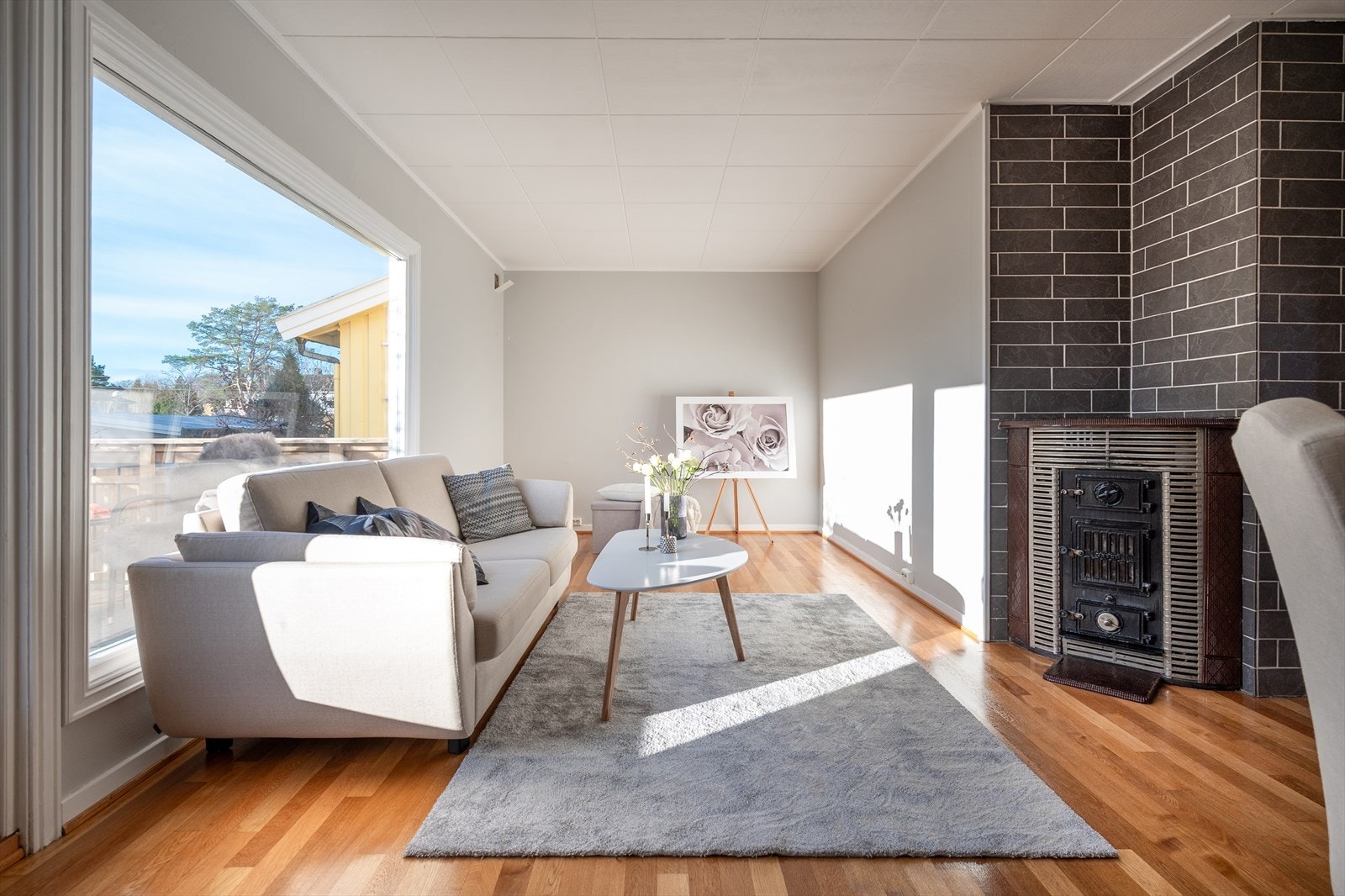 Lys og trivelig stue med store vindusflater, peisovn og direkte adkomst til den solrike terrassen. Rommet har en behagelig planløsning med god plass til både sofa- og spisegruppe. Galleribilde