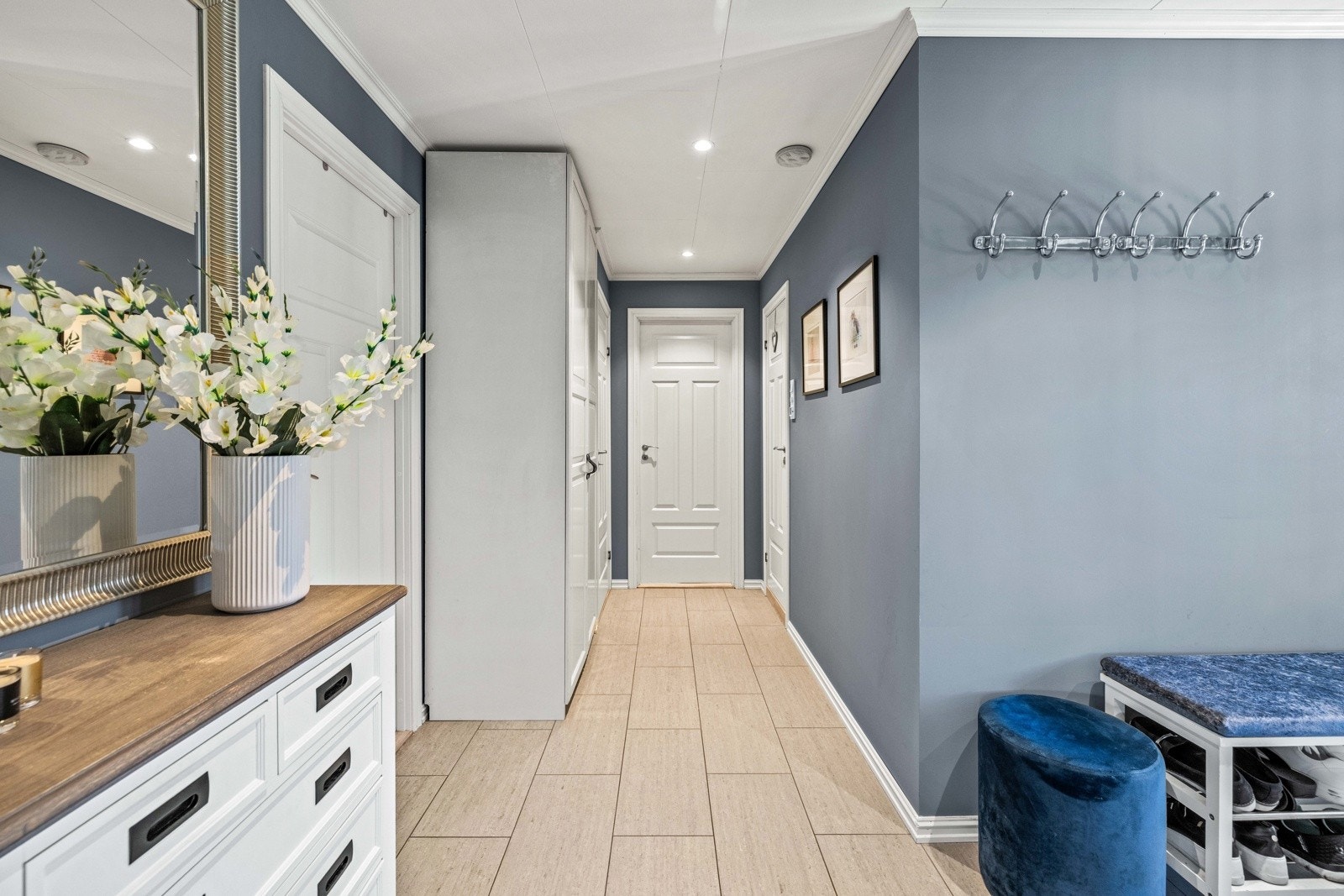 Gangen er flislagt og har god plass til oppbevaring av ytterbekledning. Galleribilde