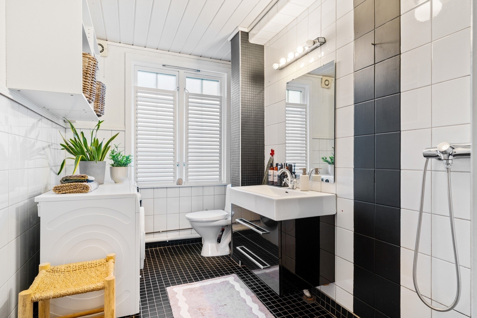 Flislagt bad på 6 kvm med servant med tilhørende baderomsmøbler, dusjhjørne og opplegg for vaskemaskin. Galleribilde