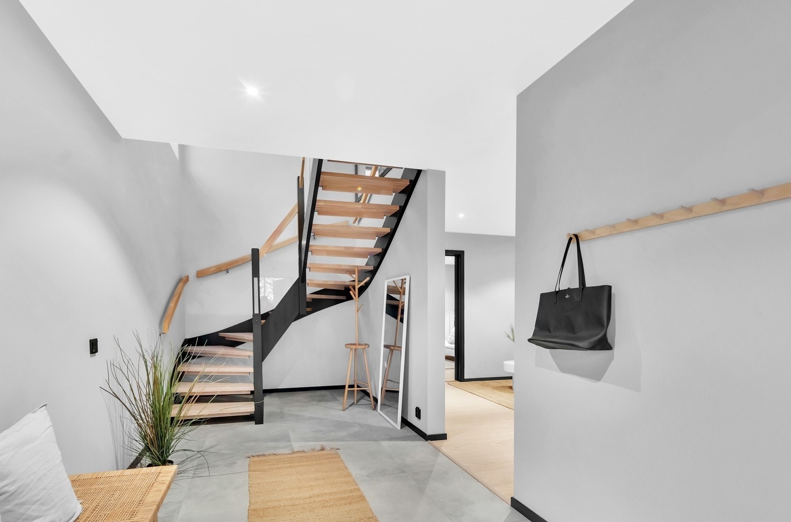 Vel innenfor døra møtes man av en romslig og meget innbydende entré som gir en god smakebit på det moderne interiøret i huset. Her er det gråmalte veggflater, downlights og store, grå gulvfliser med varme. Galleribilde